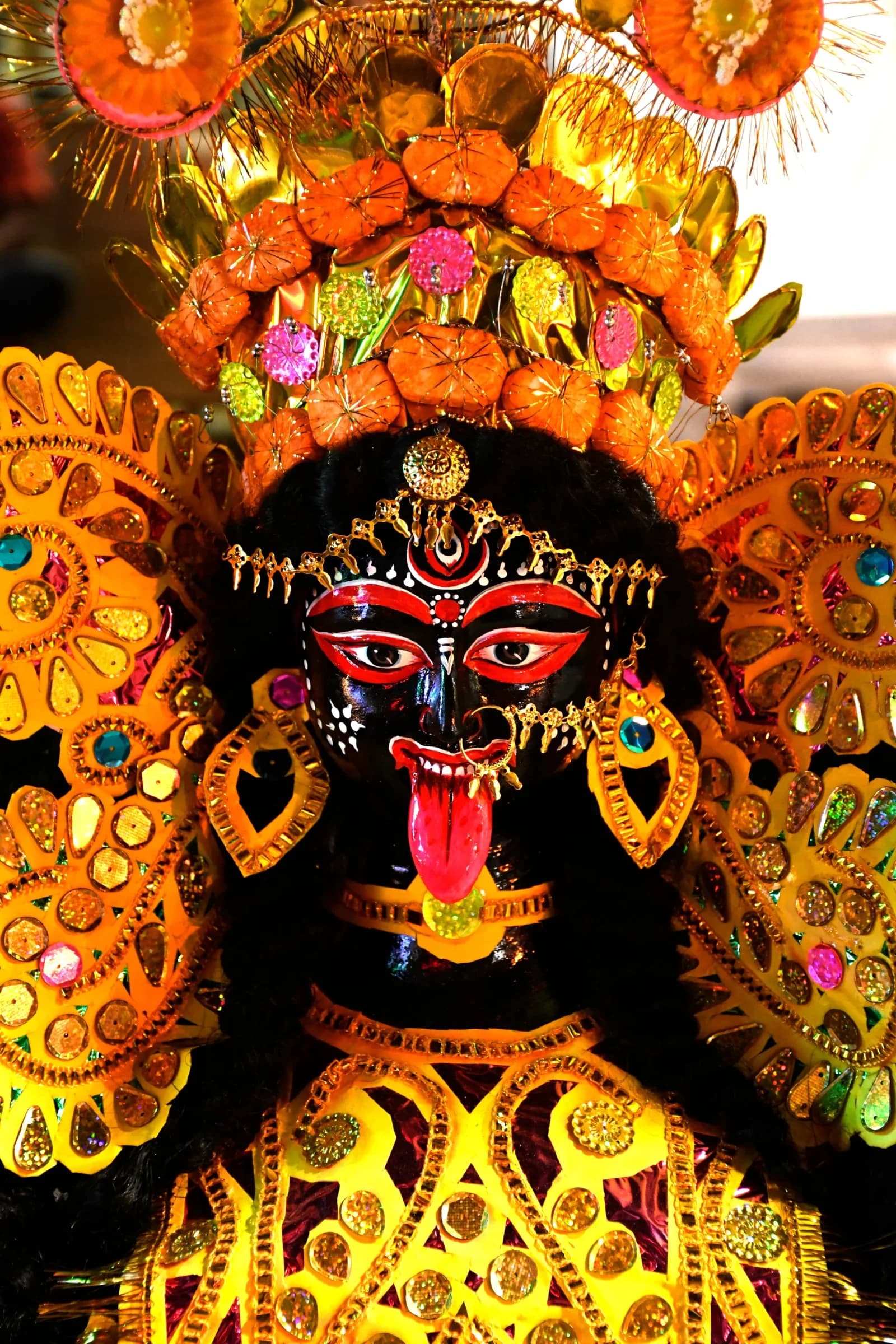 Kali murti adorned with an elaborate golden crown, ornaments and flower decorations